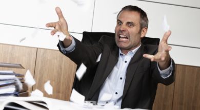 Overloaded senior businessman being upset about work, tearing pa