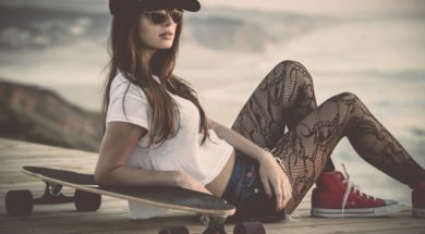 Beautiful and fashion young woman posing with a skateboard