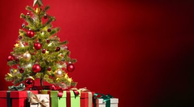 Christmas tree with gifts on red background.