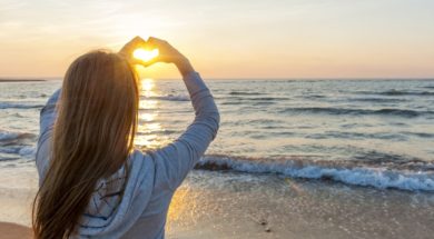 Girl Holding Hands In Heart Shape At Beach