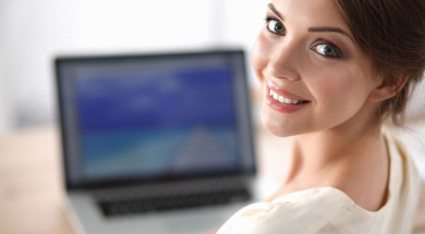 Portrait of beautiful young business woman working on a laptop a