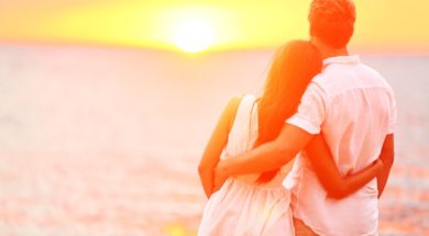 Honeymoon couple romantic in love at beach sunset. Newlywed happ