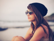 Fashion portrait of young hipster woman with hat and sunglasses